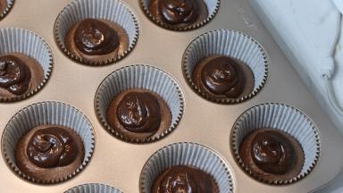 14.	将甘纳许装入裱花袋后挤在蛋糕糊中间（甘纳许挤多少没有要求，喜欢满满巧克力的可以多挤些。不过最好确保甘纳许不会挤到底部面糊边缘。甘纳许要和面糊边缘有一些空间）