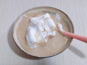 再取三分之一的蛋白霜加入蛋黄糊中，继续上面的手法，翻拌直至看不到蛋白霜。