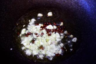 另起锅烧热后倒入花生油烧至六成热时，先加入花椒小火爆出香味后再放入大蒜末爆香。