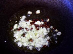 另起锅烧热后倒入花生油烧至六成热时，先加入花椒小火爆出香味后再放入大蒜末爆香。