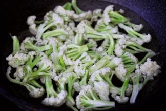 菜花用手撕成小块状，锅中倒入适量的清水烧开后，放入一勺盐后把菜花进行焯水备用。