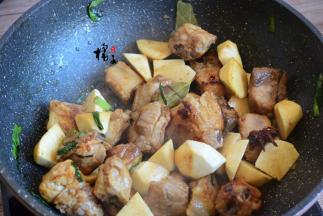 再加入芋头，加入葱姜、香叶、八角，翻炒均匀