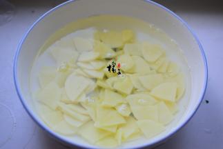 土豆去皮清洗干净，泡在水里，把表面的淀粉清洗干净