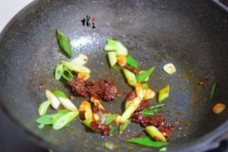 锅中再次加少许油，加入葱蒜炒出香味，加入豆瓣酱炒出红油