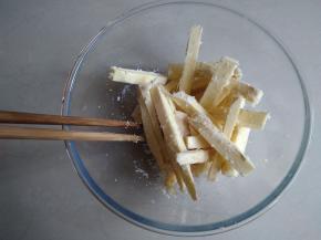 用筷子将它们拌匀，使每一根红薯条都裹上玉米油和粘上椰蓉