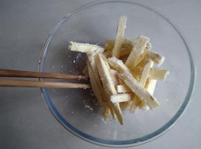 用筷子将它们拌匀，使每一根红薯条都裹上玉米油和粘上椰蓉