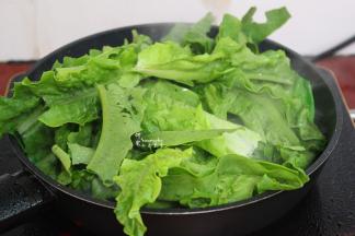 把洗净的掰的油麦菜倒入锅里，大火爆炒，用筷子不断翻转。不能停留在锅里很久，油麦菜断生味即可。