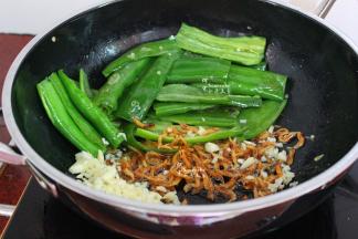 把蒜切好，虾皮洗净，放入锅里小火煸香。然后把炒的辣椒加入锅里，中火翻炒。