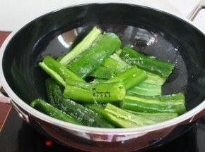 热锅，倒入适量的食用油，改为大火，把腌制好的尖椒放入锅里。然后撒点盐，用锅铲不断搓辣椒，有盐有助于辣椒容易搓起虎皮，然后出锅。