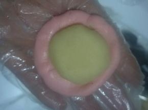 取一个水油皮按扁圆(中间厚周边薄)，包入油酥