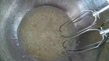 用电动打蛋器进行低速打发至鱼眼泡状态，加入余下35克糖的三分之一，再进行低速打发