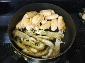 将鸡翅推到锅边，放入皮皮虾略煎一下下