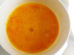 用温水泡过的鸡蛋打在碗里，用手动打蛋器搅拌均匀