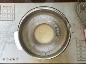 2、玉米油和水倒入盆中搅拌至乳化状态。
