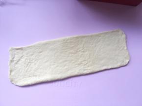 之后将擀好的面团翻转个面，将光滑的一面朝下；
