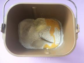 面包桶内加入高筋面粉、全蛋液、细砂糖、奶粉跟酵母