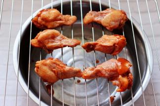 把腌好的鸡根取出，恢复室温，放在烤架上。