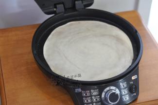 再擀成薄片，电饼铛里倒一点油刷开，放入面饼。