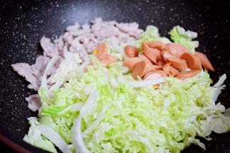 加入白菜丝和火腿肠，翻炒至断生