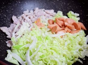 加入白菜丝和火腿肠，翻炒至断生