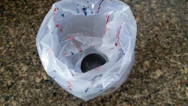 裱花嘴放进裱花袋内，套在大杯子上，用牙签挑点色素到裱花袋上，要做炫彩的，就挑几种颜色，我用了AC的大红和正蓝色