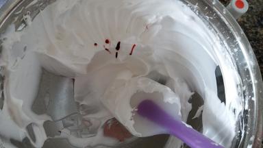 蛋白霜打发好后，去四分之一的蛋白霜装到挑有色素的裱花袋里。取二分之一的蛋白霜装入干净的裱花袋。盆里还有四分之一的蛋白霜，再用牙签挑一点红色色素，用刮刀随意拌几下后装进另一个裱花袋