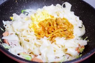 加入刀削面、鸡蛋、榨菜丝，翻炒均匀