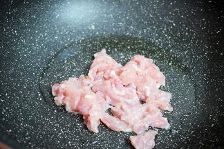 原锅倒入适量的食用油烧热，放入猪肉翻炒至变色变白