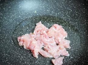原锅倒入适量的食用油烧热，放入猪肉翻炒至变色变白