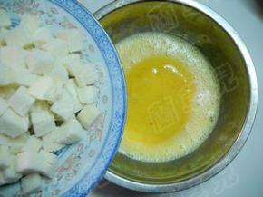 切好的馒头丁倒入蛋液中。