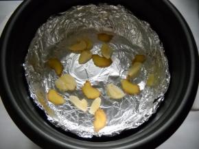 电饭锅铺入锡纸（亚光面接触食物），姜蒜铺在锡纸上。
