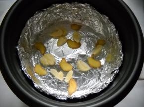 电饭锅铺入锡纸（亚光面接触食物），姜蒜铺在锡纸上。