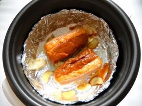 腌制好的猪肉连同料汁一起倒入饭锅中。