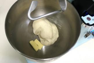 揉至成团后，往搅拌桶内加入黄油。