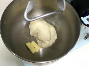揉至成团后，往搅拌桶内加入黄油。