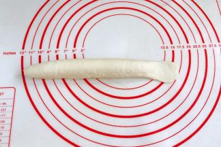 将接合处捏紧，一头搓细一头压扁擀宽，尽量擀宽些。