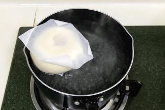 取1升的水，加入50克细砂糖，烧至微沸状态后转小火，把面胚和油纸一起入糖水锅中煮。