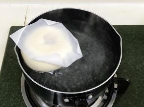 取1升的水，加入50克细砂糖，烧至微沸状态后转小火，把面胚和油纸一起入糖水锅中煮。