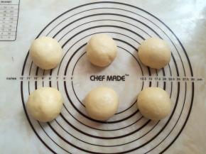 面团取出轻轻按压排气，平均分成6个，滚圆盖上保鲜膜松弛15分钟