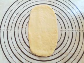 .取一个面团擀成牛舌状，底部擀薄