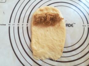 顶部放上适量的肉松，从上往下卷起来，收口处捏紧朝下。