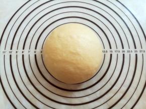 面团取出轻轻按压排气，滚圆后盖上保鲜膜松弛15分钟