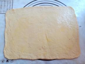 融化黄油，把面团擀成23*36厘米的长方形，在面团上刷上一层薄薄的黄油，四周留1厘米不刷