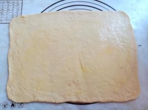 融化黄油，把面团擀成23*36厘米的长方形，在面团上刷上一层薄薄的黄油，四周留1厘米不刷