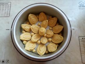 准备1个8寸的圆形模具，在模具底部垫一张油纸，模具内壁抹一层黄油，把10个比较高的面团紧贴模具围成一圈，切面向内，第二圈放5个小面团，花型面团放正中间，还有半块面团撕成小圆点放到面团中间的空位里