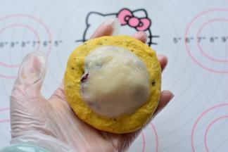 取一个面团，用手捏成圆形，把麻薯放在上面