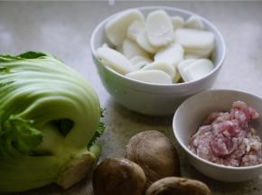 这款汤年糕的备料：切片的年糕500克，圆芥菜1个，香菇4朵，肉末100克。