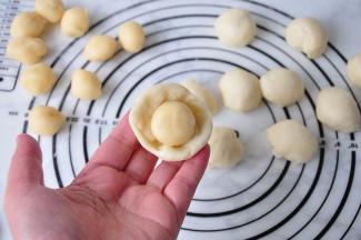 取一个油皮按扁，包上油酥。醒好的面团是非常喧软的，但延展性极强，所以，您不必担心。