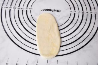 取其中一份擀长。采用从中间开始，向上一下，再向一下的方法，一气呵成。