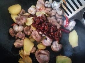 鸡杂完全炒变色后，沿锅边倒入适量料酒，翻炒均匀，之后放入豆瓣酱，翻炒